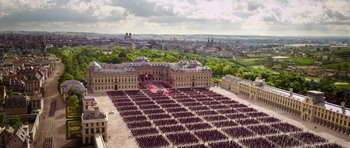 Movie still from “The Three Musketeers” (2011), directed by Paul W.S. Anderson – An aerial view of a large group of people standing in front of a building; Extreme Wide shot, High angle