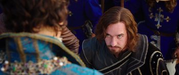 Movie still from “The Three Musketeers” (2011), directed by Paul W.S. Anderson – A man with long hair and a beard is looking at another man; Close Up shot, Over the shoulder angle