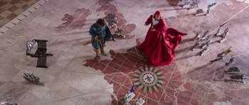 Movie still from “The Three Musketeers” (2011), directed by Paul W.S. Anderson – Two people dressed in medieval costumes are standing on the floor; Extreme Wide shot, Overhead angle