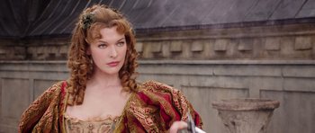 Movie still from “The Three Musketeers” (2011), directed by Paul W.S. Anderson – A beautiful woman in a medieval dress holding a sword; Close Up shot, Over the shoulder angle