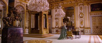 Movie still from “The Three Musketeers” (2011), directed by Paul W.S. Anderson – A woman dressed in period clothing in a room with chandeliers; Wide shot, High angle