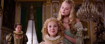 Movie still from “The Three Musketeers” (2011), directed by Paul W.S. Anderson – Two women dressed in period clothing and one of them has a crown on her head; Close Up shot, Low angle
