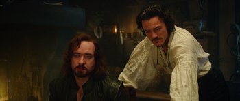 Movie still from “The Three Musketeers” (2011), directed by Paul W.S. Anderson – Two men in medieval garb looking at the camera; Medium shot, Over the shoulder angle