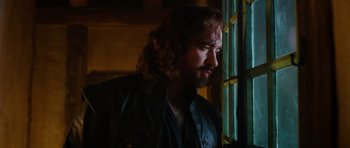 Movie still from “The Three Musketeers” (2011), directed by Paul W.S. Anderson – A man with long hair looking out of a window; Close Up shot, Over the shoulder angle