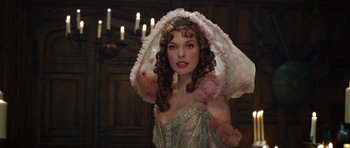 Movie still from “The Three Musketeers” (2011), directed by Paul W.S. Anderson – A woman with long hair and a pink hat; Close Up shot, Over the shoulder angle