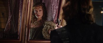 Movie still from “The Three Musketeers” (2011), directed by Paul W.S. Anderson – A woman is looking in the mirror while holding a cell phone; Close Up shot, Over the shoulder angle