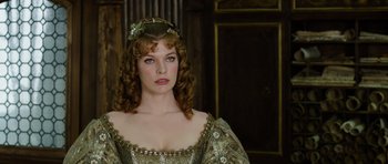 Movie still from “The Three Musketeers” (2011), directed by Paul W.S. Anderson – A woman in a gold dress and a crown; Close Up shot, Low angle