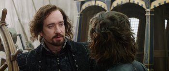 Movie still from “The Three Musketeers” (2011), directed by Paul W.S. Anderson – A man with long hair talking to another man; Close Up shot, Over the shoulder angle