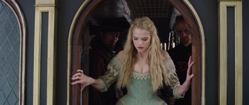 Movie still from “The Three Musketeers” (2011), directed by Paul W.S. Anderson – A woman in a green dress standing in front of a mirror; Medium shot, Over the shoulder angle