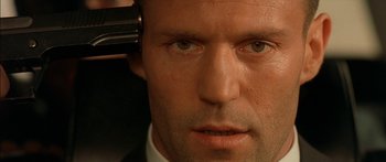Movie still from “The Transporter” (2002), directed by Corey Yuen – A person with a hair dryer on his head; Close Up shot, Low angle