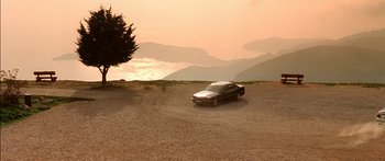 Movie still from “The Transporter” (2002), directed by Corey Yuen – A car is parked on the side of the road; Extreme Wide shot, High angle
