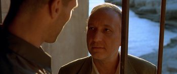 Movie still from “The Transporter” (2002), directed by Corey Yuen – A man in a suit is looking at another man in a suit; Close Up shot, Over the shoulder angle