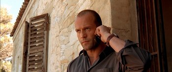 Movie still from “The Transporter” (2002), directed by Corey Yuen – A man holding a cell phone up to his ear; Close Up shot, Low angle