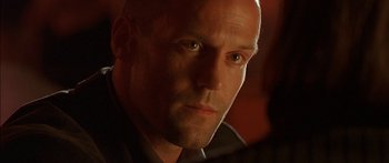 Movie still from “The Transporter” (2002), directed by Corey Yuen – A man's face in a dark room; Close Up shot, Low angle
