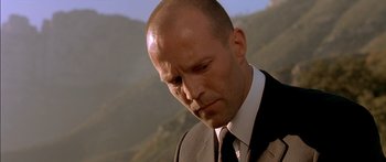 Movie still from “The Transporter” (2002), directed by Corey Yuen – A man in a suit and tie looking down; Close Up shot, Low angle