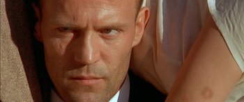 Movie still from “The Transporter” (2002), directed by Corey Yuen – A man's face in a white shirt; Close Up shot, Low angle