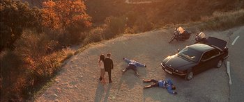 Movie still from “The Transporter” (2002), directed by Corey Yuen – A group of people standing on top of a dirt hill; Extreme Wide shot, Overhead angle