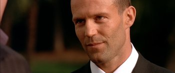 Movie still from “The Transporter” (2002), directed by Corey Yuen – A person wearing a suit and tie; Close Up shot, Low angle