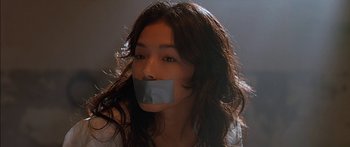 Movie still from “The Transporter” (2002), directed by Corey Yuen – A woman with duct tape over her mouth; Close Up shot, Low angle