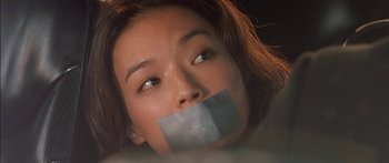 Movie still from “The Transporter” (2002), directed by Corey Yuen – A woman with a duct tape over her mouth; Close Up shot, Low angle