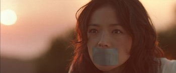 Movie still from “The Transporter” (2002), directed by Corey Yuen – A woman with a duct tape over her mouth; Close Up shot, Low angle