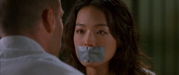 Movie still from “The Transporter” (2002), directed by Corey Yuen – A woman with duct tape over her mouth; Close Up shot, Over the shoulder angle