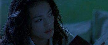 Movie still from “The Transporter” (2002), directed by Corey Yuen – A beautiful young lady sitting in front of a laptop; Close Up shot, Low angle