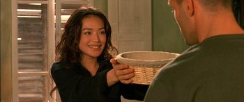 Movie still from “The Transporter” (2002), directed by Corey Yuen – A woman holding a basket in front of a man; Close Up shot, Over the shoulder angle