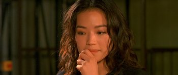 Movie still from “The Transporter” (2002), directed by Corey Yuen – A young woman is holding her hand to her face; Close Up shot, High angle