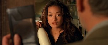 Movie still from “The Transporter” (2002), directed by Corey Yuen – A young woman holding a hair dryer in her hand; Close Up shot, Over the shoulder angle