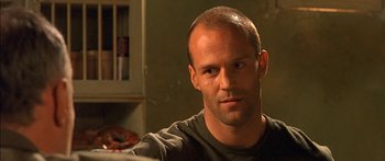 Movie still from “The Transporter” (2002), directed by Corey Yuen – A person wearing a t - shirt; Close Up shot, Over the shoulder angle