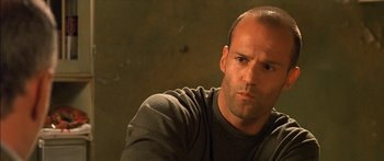 Movie still from “The Transporter” (2002), directed by Corey Yuen – A man with a bald head is looking at the camera; Close Up shot, Low angle