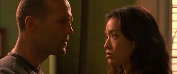 Movie still from “The Transporter” (2002), directed by Corey Yuen – A man and a woman face to face in front of a mirror; Close Up shot, Over the shoulder angle