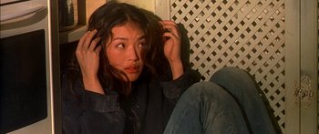 Movie still from “The Transporter” (2002), directed by Corey Yuen – A woman sitting on the ground with her hands in her hair; Close Up shot, High angle