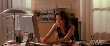 Movie still from “The Transporter” (2002), directed by Corey Yuen – A woman sitting in front of a computer monitor; Medium shot, High angle