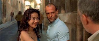 Movie still from “The Transporter” (2002), directed by Corey Yuen – A man and a woman standing next to each other in front of a building; Close Up shot, Over the shoulder angle