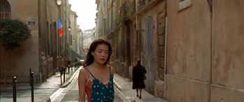 Movie still from “The Transporter” (2002), directed by Corey Yuen – A woman walking down the street in a blue dress; Medium shot, Over the shoulder angle