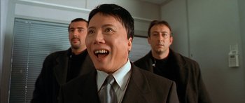 Movie still from “The Transporter” (2002), directed by Corey Yuen – A group of men standing next to each other in a room; Close Up shot, Low angle