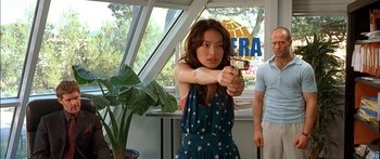 Movie still from “The Transporter” (2002), directed by Corey Yuen – A woman holding a gun in a room; Medium shot, Low angle