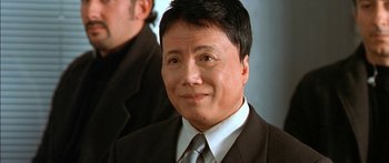 Movie still from “The Transporter” (2002), directed by Corey Yuen – A person wearing a suit and tie; Close Up shot, Low angle