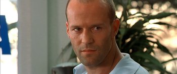 Movie still from “The Transporter” (2002), directed by Corey Yuen – A man with a bald head; Close Up shot, Low angle