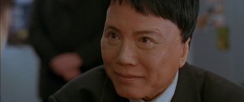 Movie still from “The Transporter” (2002), directed by Corey Yuen – A person wearing a suit and tie; Close Up shot, High angle