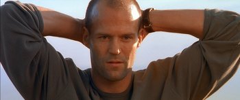 Movie still from “The Transporter” (2002), directed by Corey Yuen – A bald man with his hands behind his head; Close Up shot, Low angle
