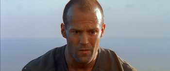 Movie still from “The Transporter” (2002), directed by Corey Yuen – A man with a shaved head and a bald head; Close Up shot, Low angle