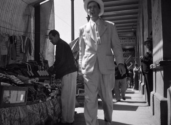 Movie still from “The Treasure of the Sierra Madre” (1948), directed by John Huston – An old photo of a man walking down the street; Wide shot, Low angle
