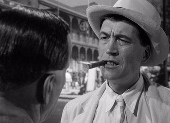 Movie still from “The Treasure of the Sierra Madre” (1948), directed by John Huston – A man smoking a cigarette while talking to another man; Close Up shot, Over the shoulder angle