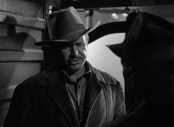 Movie still from “The Treasure of the Sierra Madre” (1948), directed by John Huston – A black and white photo of a man wearing a hat; Close Up shot, Over the shoulder angle
