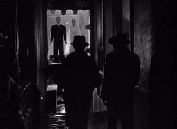 Movie still from “The Treasure of the Sierra Madre” (1948), directed by John Huston – A group of men standing next to each other in front of a building; Wide shot, Low angle