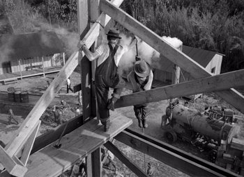 Movie still from “The Treasure of the Sierra Madre” (1948), directed by John Huston – Two men are working on a structure in a field; Wide shot, Low angle