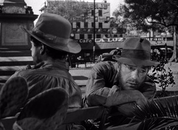 Movie still from “The Treasure of the Sierra Madre” (1948), directed by John Huston – Two men sitting next to each other on a park bench; Medium shot, Over the shoulder angle